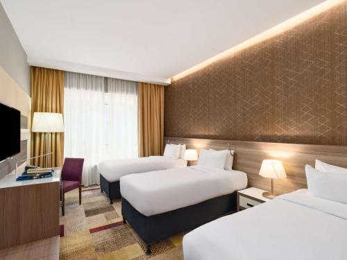 メッカにあるMercure Makkah Aziziahのベッド2台とテレビがあるホテルの部屋