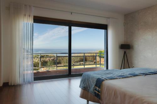 a bedroom with a large window with a view of the ocean at Villa Mastlo in Assenta