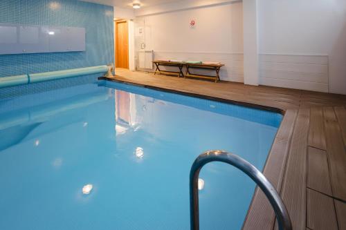 a large swimming pool with a bench in a room at Villa Mastlo in Assenta