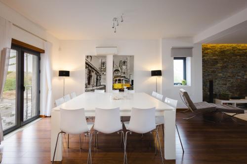 a white dining room with a white table and chairs at Villa Mastlo in Assenta