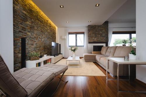 a living room with a couch and a brick wall at Villa Mastlo in Assenta