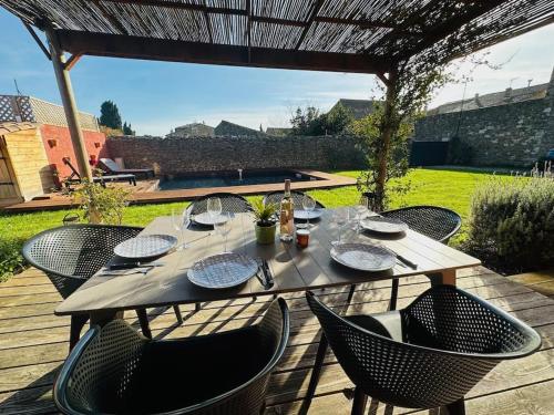 une table en bois avec des chaises et une tableastery ... dans l'établissement Ancien chai rénové avec piscine, à Paraza