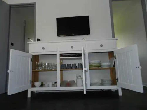 d'une armoire blanche avec une télévision. dans l'établissement Villa dans résidence de vacances avec piscine, tennis et aire de jeux, à Soustons