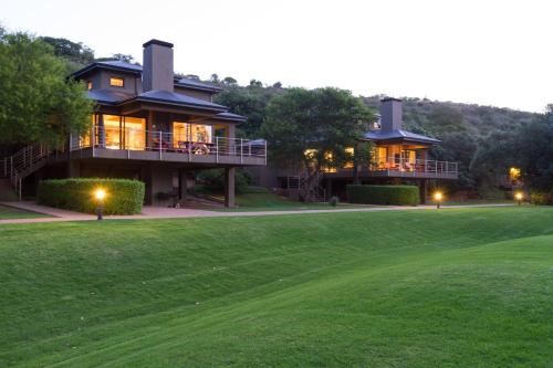 a house on a hill with a green yard at Stonehill River Lodge by Dream Resorts in Buffeljagsrivier