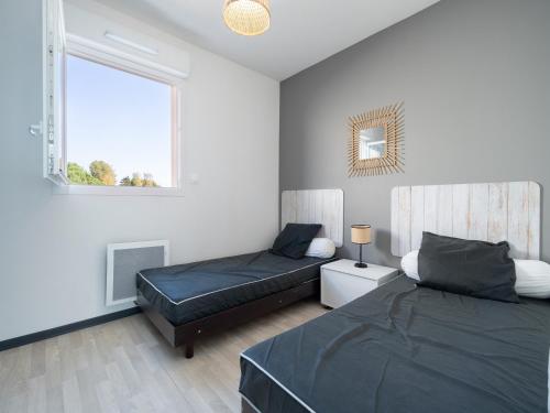 une chambre avec deux lits et une fenêtre dans l'établissement La Dune 42 - Villa 5P8, à Sérignan