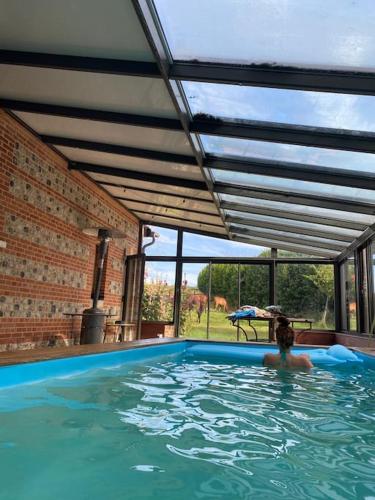 une femme dans une piscine dans une maison dans l'établissement Grande et belle maison ancienne restaurée, à Écrainville
