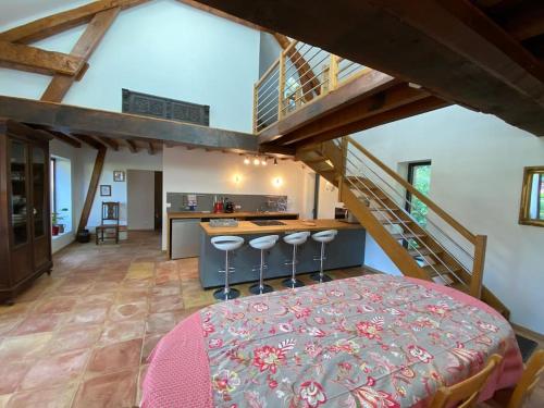 a large room with a bed and a staircase at Grande et belle maison ancienne restaurée in Écrainville