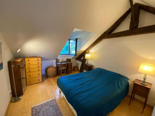 a bedroom with a blue bed in a attic at Grande et belle maison ancienne restaurée in Écrainville