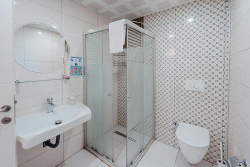 a bathroom with a shower and a toilet and a sink at Fortunella Suites in Finike