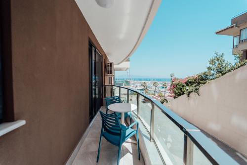 a balcony with two chairs and a table on it at Fortunella Suites in Finike