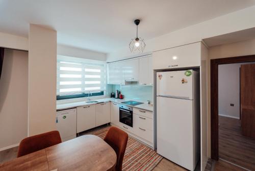 a kitchen with a white refrigerator and a table at Fortunella Suites in Finike