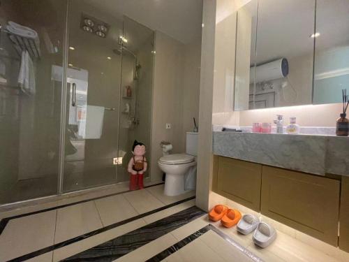 a bathroom with a shower and a teddy bear next to a toilet at Shanghai Lerongju Boutique Apartment Metro Line 8 20meter in Shanghai