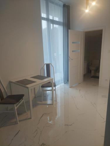 a dining room with a table and two chairs at Apartamenty Nogalin in Józefów
