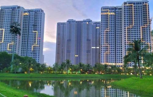 a city skyline with tall buildings and a pond at Saigon Luxury Apartment in Long Bình