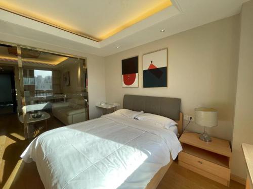 a bedroom with a large white bed and a living room at Shanghai Lerongju Boutique Apartment Metro Line 8 20meter in Shanghai