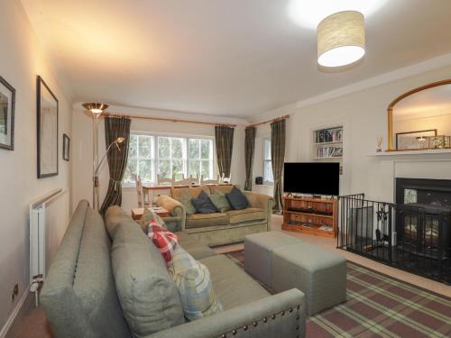 a living room with a couch and a tv at Inverewe - Garden Lodge in Achnasheen