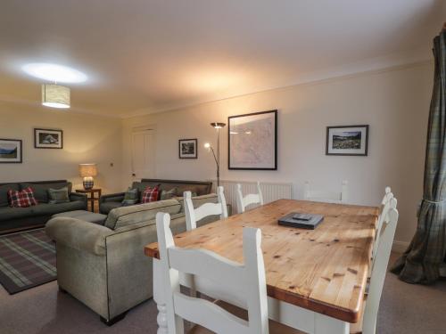 a living room with a wooden table and a couch at Inverewe - Garden Lodge in Achnasheen