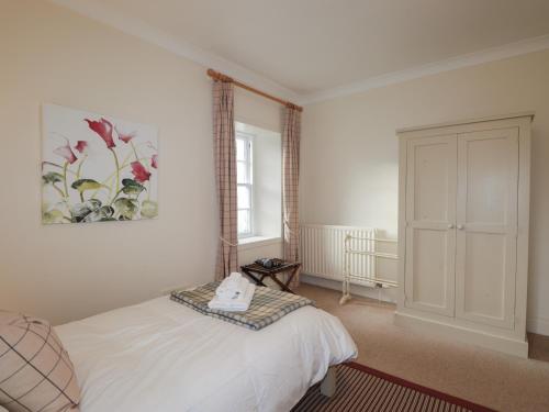 a bedroom with a bed and a picture on the wall at Inverewe - Garden Lodge in Achnasheen
