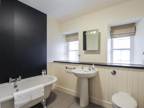 a bathroom with a bath tub and a sink at Inverewe - Garden Lodge in Achnasheen