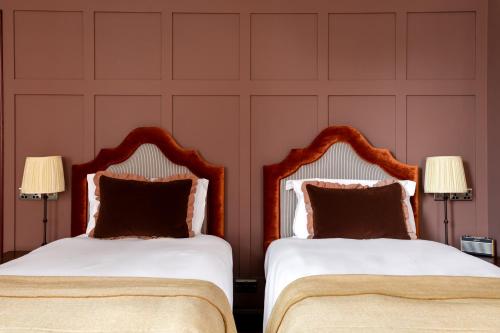 two beds sitting next to each other in a bedroom at The Brewers Inn in London