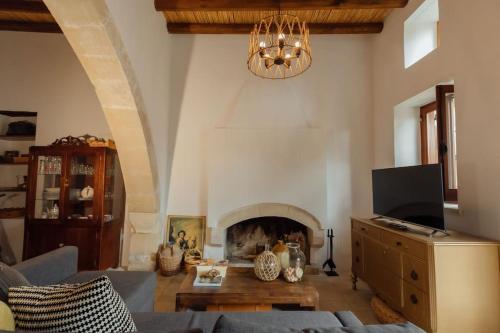 a living room with a couch and a fireplace at The Yard Traditional Residence in Vasa Kilaniou