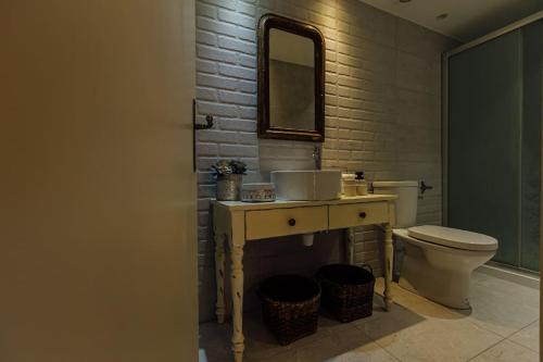 a bathroom with a toilet and a sink and a mirror at The Yard Traditional Residence in Vasa Kilaniou