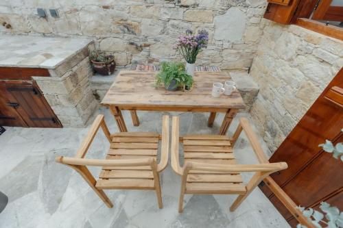 a wooden table and four chairs on a patio at The Yard Traditional Residence in Vasa Kilaniou