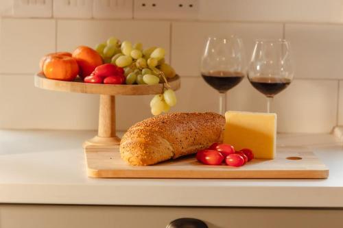 a cutting board with a loaf of bread and two glasses of wine at The Yard Traditional Residence in Vasa Kilaniou