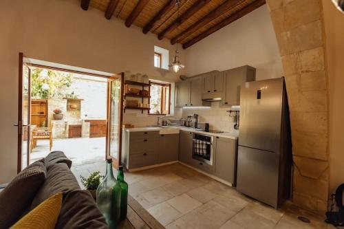 a kitchen with a stainless steel refrigerator freezer at The Yard Traditional Residence in Vasa Kilaniou