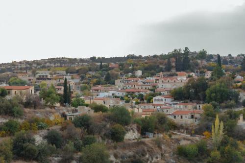 a group of houses on a hill with trees at The Yard Traditional Residence in Vasa Kilaniou