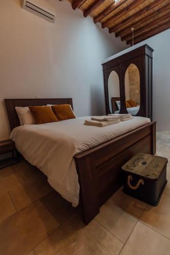 a bedroom with a large bed with a wooden frame at The Yard Traditional Residence in Vasa Kilaniou