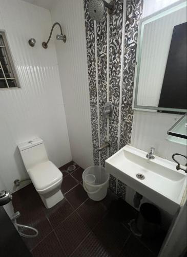 a bathroom with a toilet and a sink at Western Keys Hotel in Bengaluru