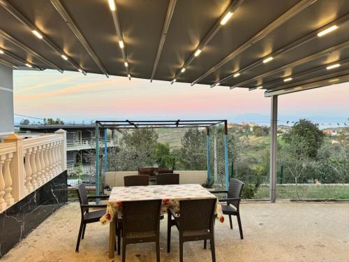 a dining room with a table and chairs on a patio at The Grey Cottage in Durrës