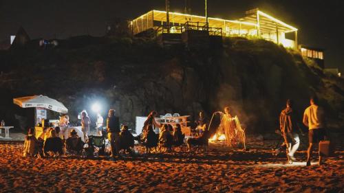 a group of people sitting around a fire on the beach at night at Sahil Kamp İstanbul Hotel in Sile