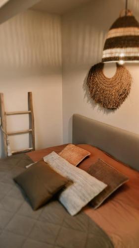 a bed with two pillows on it with a chandelier at Dune Du Clémot in Blankenberge