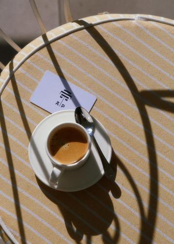 a cup of coffee on a table with a spoon at Apollo Palm Hotel in Athens
