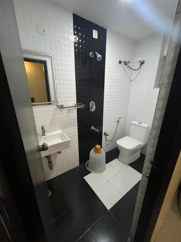 a bathroom with a toilet and a sink at Western Keys Hotel in Bengaluru