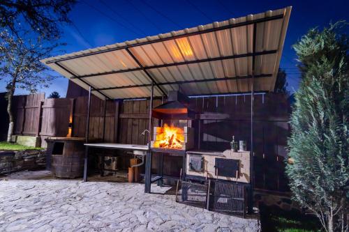 an outdoor kitchen with a fireplace in a backyard at Bob’house in Vulcan