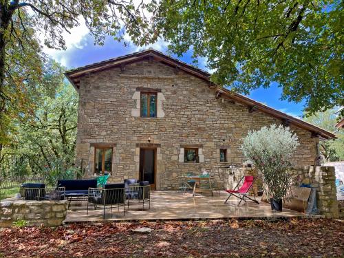 une maison en pierre avec des chaises et une terrasse dans l'établissement La Boca Noche Chambres d'Hotes et Gite, à Saint-Antonin
