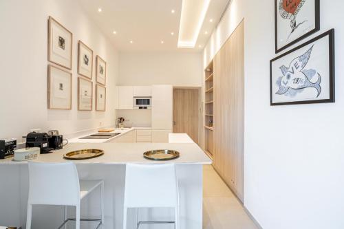 une cuisine avec un grand îlot blanc et des tabourets dans l'établissement REF 1975 - Cannes Center - Croisette, à Cannes