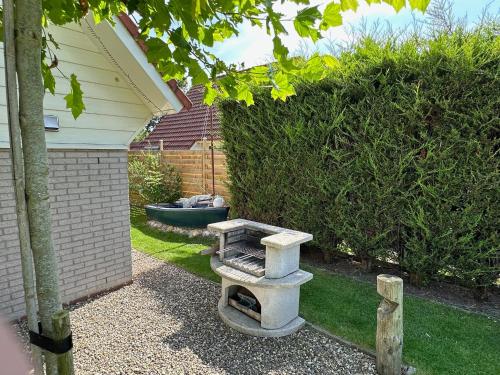 a garden with a stone bench in a yard at "ZeeLandZon" Holiday home by the lake with Jacuzzi and Sauna in Herkingen