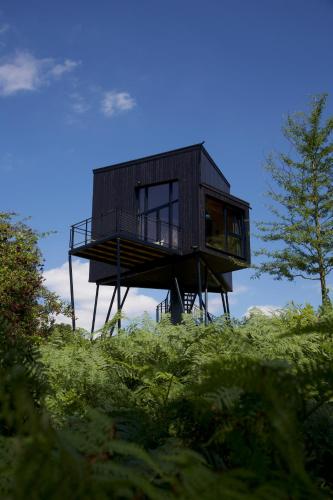 a black house sitting on top of a hill at Treeangle - K1 Baumhaus in Odenthal
