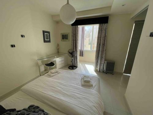 a bedroom with a white bed and a window at Charming 2-bedroom 2 bath apartment - Sliema in Sliema