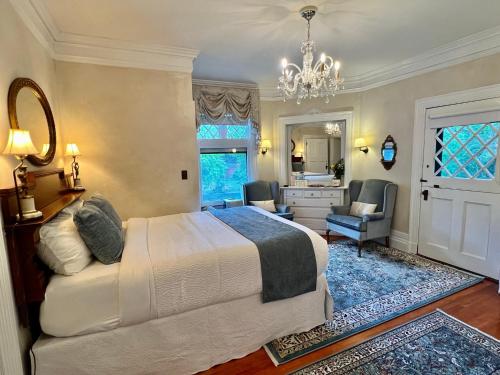 a bedroom with a white bed and a bathroom at Manor House Inn in Norfolk