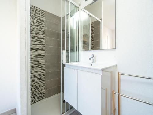 une salle de bain avec un lavabo blanc et un miroir dans l'établissement La Dune 68 - VILLA 4P8, à Sérignan