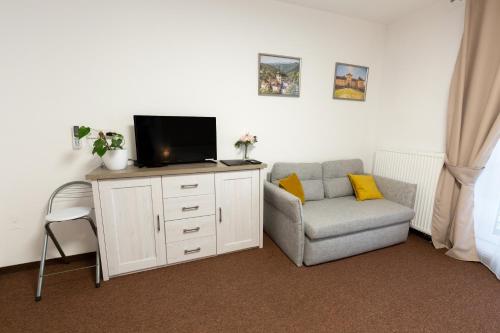 a living room with a tv and a chair at BASELINE športový areál & penzión in Banská Bystrica