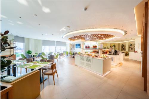 a restaurant with a cafeteria with tables and chairs at Hilton Garden inn Dubai Jumeirah in Dubai