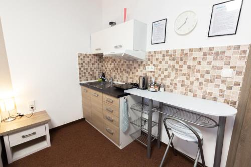 a small kitchen with a counter and a table and chairs at BASELINE športový areál & penzión in Banská Bystrica