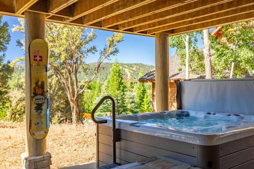 a hot tub on a patio with a view at Hot Tub Game Room Large Deck w Incredible View Penticton Lodge by AvantStay in Big Bear Lake
