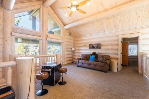 a log cabin living room with a ceiling fan at Hot Tub Game Room Large Deck w Incredible View Penticton Lodge by AvantStay in Big Bear Lake